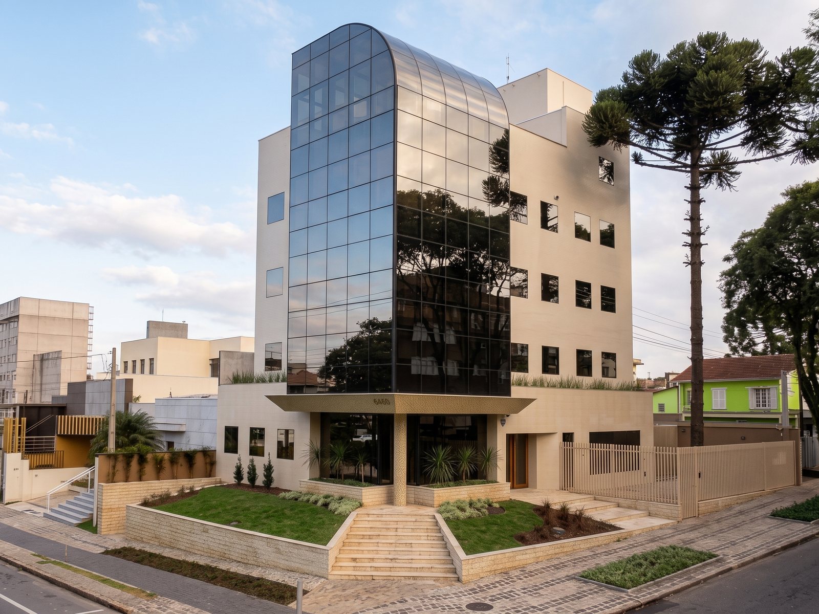 O mesmo edifício construído, com a torre de vidro e araucárias